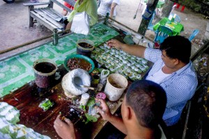 To go with MYANMAR-LIFESTYLE-HEALTH by Reuben EASEY This photo taken on July 12, 2015 shows betel sellers preparing 'kun ja' at their shop near Naypyidaw in Myanmar. Kun ja is an enormously popular stimulant chewed throughout Myanmar. But it comes with a long list of serious health downsides including addiction, deeply stained gums and a high risk of mouth cancer. The small parcels of tobacco, areca nuts, slaked lime and optional spices, wrapped in the vivid green leaves of the betel plant, are ubiquitous across the former junta-run nation. AFP PHOTO / Ye Aung THU